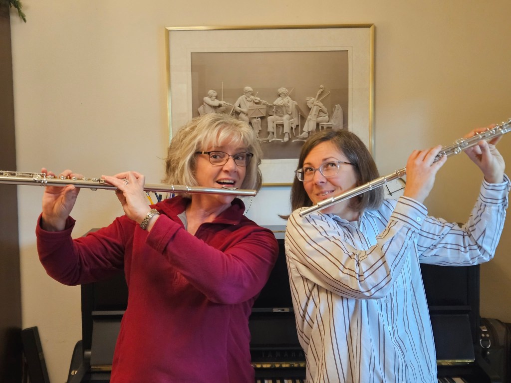 Cheryl and Erica playfully posing with their flutes in mirror image - Erica is holding hers "backwards" - as the Doppler Brothers did